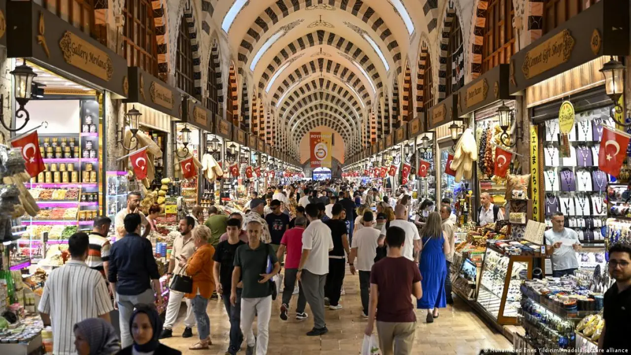 İstanbul Kapalı Çarşı'da dükkanların önünde duran satıcılar ve önlerinden geçen kalabalık.
